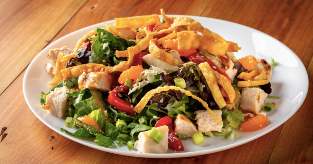 An Asian Chicken Salad with wonton strips, veggies, and dressing. 