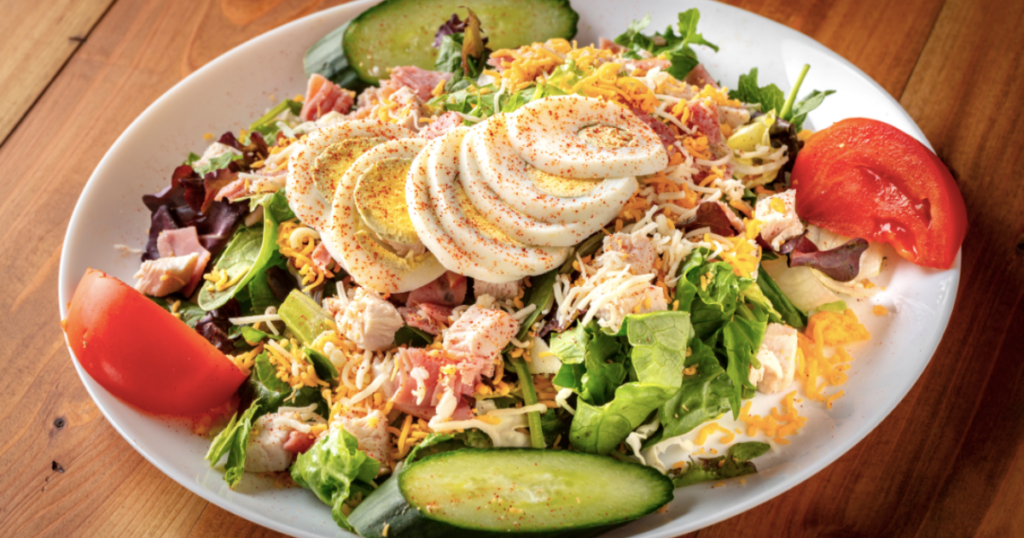 A classic Chef Salad with turkey, ham, egg, cheese, cucumber, and tomato.